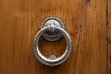 Eski bir kapı tokmağının ahşap bir kapının üzerindeki klasik süslenmiş görüntüsü..