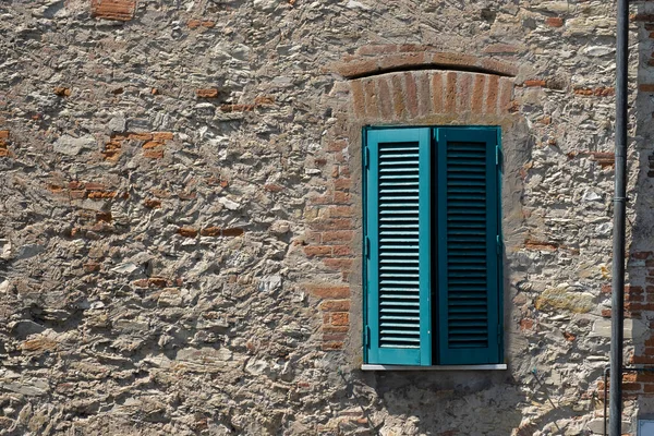 茶色のレンガの壁の背景に古い木製の窓小さな窓のある石の壁 — ストック写真