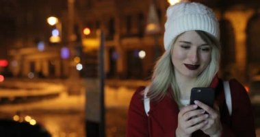 Güzel genç kadın geceleri sokak cep telefonu kullanarak açık portresi. Kış, neşeli Noel arka plan üzerinde Fuarı.