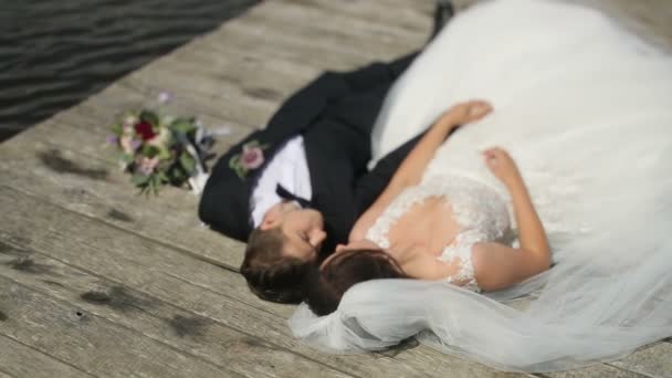 Vackra bröllopsparet. Eleganta mjuka eleganta brudgummen och bruden nära flod eller sjö. Par i kärlek — Stockvideo