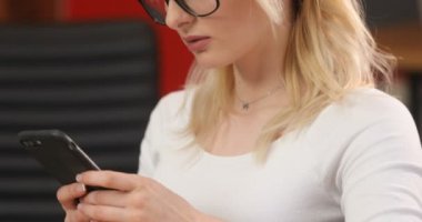 Ofiste çalışan başarılı iş kadın. Akıllı telefon kullanarak ve kahve içme onun işyerinde bardaklarda muhteşem genç businesslady