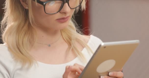 Erfolgreiche Geschäftsfrau im Büro. hinreißende junge Geschäftsfrau mit Brille an ihrem Arbeitsplatz mit Tablet-Computer — Stockvideo