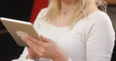 Tablet bilgisayar kullanarak onun işyerinde bardaklarda muhteşem genç businesslady