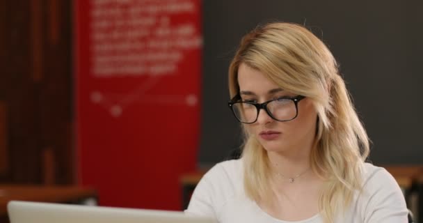 Stijlvolle blonde vrouw werken in office. Kaukasische meisje scrollen van pagina's, het lezen van nieuws op het internet — Stockvideo