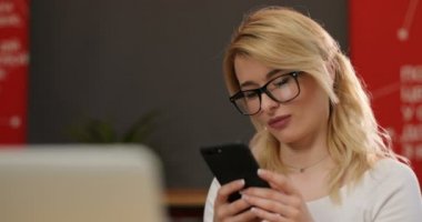 Yakın çekim Genç mutlu portre sarışın kadın akıllı telefon ve güleryüzlü sohbet gülümsedi. Kapalı.