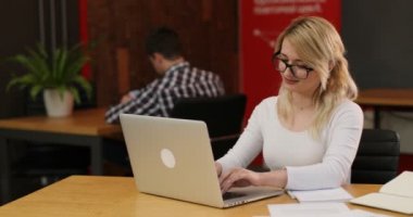 Ofiste çalışan şık sarışın kadın. Onu laptop kullanarak Internet haber okuma sayfa, kaydırma beyaz bir kız. Ekip çalışması insanlar kavramı