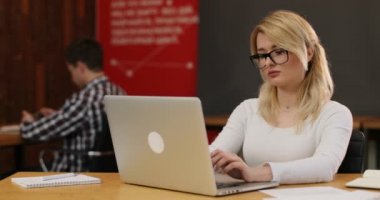 Ofiste çalışan şık sarışın kadın. Onu laptop kullanarak Internet haber okuma sayfa, kaydırma beyaz bir kız. Ekip çalışması insanlar kavramı