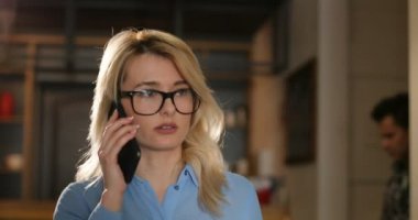 Alan coworking yakışıklı genç kız ofiste smartphone kullanarak gözlük. . Ofiste, kapalı telefonda konuşurken iş kadın hücresi kapatın. Portre vurdu