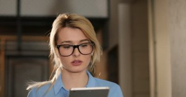 Alan coworking ofisine, tablet PC'yi kullanma yakışıklı genç kadın. . Ofiste, kapalı telefonda konuşurken iş kadın hücresi kapatın. Portre vurdu