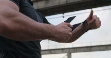 Kas spor adam yumruk bandaj ve sabah egzersiz açık hazırlama eğitimi ağırlık ile yakın uo vurdu. Kentsel, endüstriyel. Güç ve motivasyon. Isınma kadar fitness adam