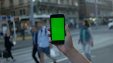 Mans ve insanlar Tren İstasyonu zemin üzerine yeşil ekranlı akıllı telefon tutarak. Yakın çekim. Chroma anahtar.