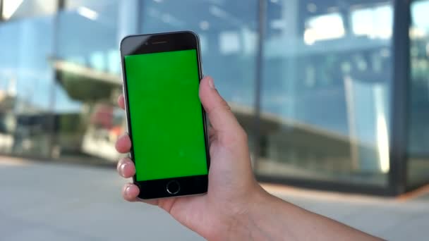 남자 손 공항 창 배경에 녹색 스크린 스마트 휴대 전화를 들고. 닫습니다. 크로마 키. — 비디오