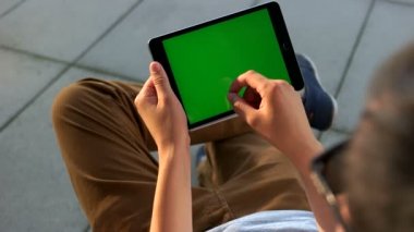 Adam ellerini tablet ile yeşil ekran havaalanında arkadaşlarınızla sohbet için kullanma. Yakın çekim. Chroma anahtar.