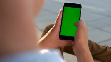 Adam havaalanında arkadaşlarınızla sohbet için yeşil perde ile akıllı telefon kullanarak eller. Yakın çekim. Chroma anahtar. Arkadan görüntülemek.
