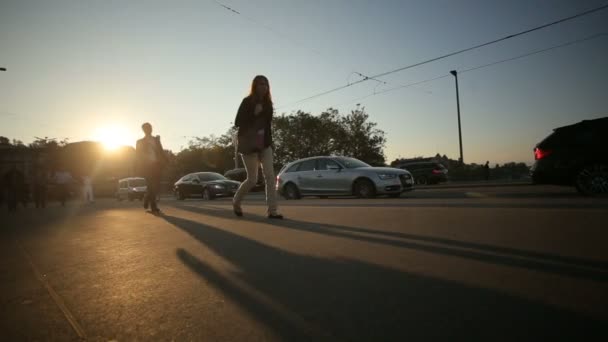 Les gens marchant dans la rue de la ville, voiture passe à travers la rue sur fond de coucher de soleil. Zurich, Suisse 22.08.2016 — Video