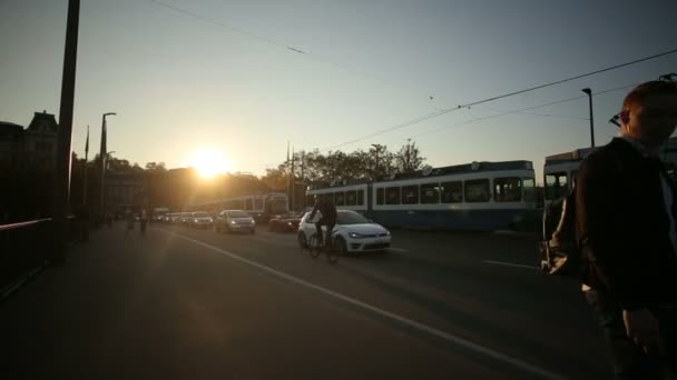 Uitzicht op de stad straat, auto's, tram is rijden op de straat, mensen lopen tijdens zonsondergang. Zurich, Zwitserland 22.08.2016 — Stockvideo