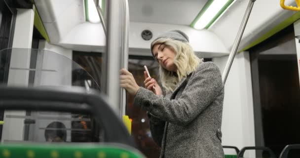 Joven linda chica marcando y llamando al teléfono inteligente en el transporte público — Vídeos de Stock