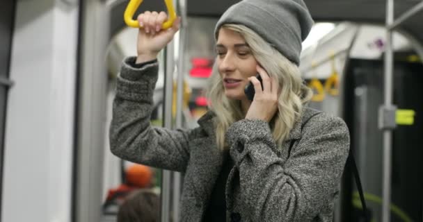 Joven mujer feliz hablando por teléfono y sosteniendo barandilla público transporte . — Vídeo de stock