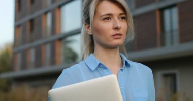 Genç Sarışın kadın güzel bakmak ve doğal yakın çekim portre yapmak gülümseyerek kameraya bakıyor. Modern mimari bina arka plan