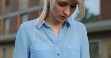 Genç Sarışın kadın açık havada otururken dizüstü bilgisayar kullanan yakın çekim portresi. İnternette bilgi aramak için bir kişisel dizüstü bilgisayar kullanan kız