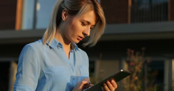 Retrato de close-up de uma bela mulher de negócios segurando e usando tablet fora. Arquitetura moderna edifício fundo — Vídeo de Stock