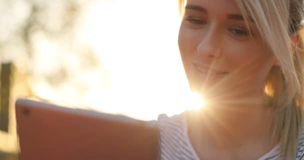 Retrato de close-up de uma jovem estudante usando tablet no parque. Menina fazendo compras on-line no tablet pc — Vídeo de Stock