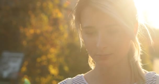 Retrato de menina de verão, close-up retrato de menina estudante atraente andando na rua urbana e usando smartphone moderno fora, luz do sol — Vídeo de Stock