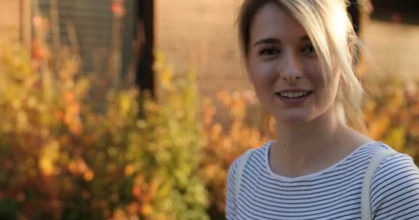 Close-up retrato de atraente jovem mulher olhando para a câmera e sorrisos — Vídeo de Stock