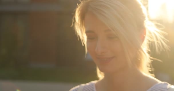 Close-up retrato de menina estudante atraente andando na rua urbana e usando smartphone moderno fora, luz do sol — Vídeo de Stock