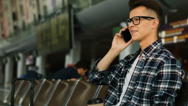 Jovem Atraente Nos Óculos Conversando Telefone Inteligente Com Amigos Enquanto — Vídeo de Stock