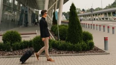 Şık genç iş adamı Havaalanı lounge bölgesine terminal yürüme Bagaj ile.