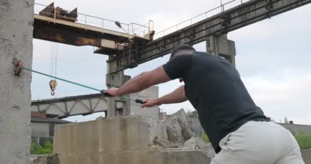 Träning träning. Porträtt av friska stilig aktiva mannen med vältränad muskulös kropp gör expander stretching övningar utomhus. Sportig manliga utbildning utomhus. Sport och fitness koncept — Stockvideo