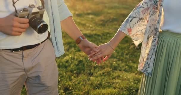 Acercamiento de la joven pareja tomando unos a otros Han y sosteniendo. Hombre y mujer de la mano. Turistas con cámara en la naturaleza . — Vídeos de Stock