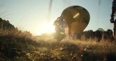 Aşağıdan görüntülemek ve pitoresk sunset Bulvarında büyük balon alanında çalışan mutlu genç çift çimen.