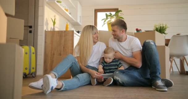 glückliches Familienporträt mit Tablet-Computer. Mann und Frau und ihr kleiner Sohn ziehen in ein neues Zuhause. Hypothek, Menschen, Wohnungs- und Immobilienkonzept.