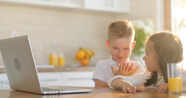 Duas crianças felizes brincando com laptop. Crianças ou amigos com computador em casa. Crianças, tecnologia, ciência e conceito de pessoas — Vídeo de Stock