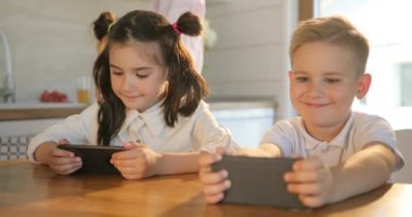 Şirin ve akıllı telefon evde zevk kız. Kız çocuk ve bir dijital tablet vasıl kithen oynamaktan çocuk. Bir akıllı holding ve elinde çocuk izlerken telefonu. Teknoloji akıllı telefon arka plan