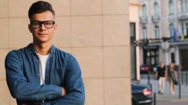 El crossing, şehrin kamerada isteyen ve gülümseyen rahat tişörtlü genç şık adam portresi.