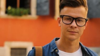 Turuncu duvar arka plan üzerinde şehirde bardaklarda genç şık adam portresi. Atış kapatın.