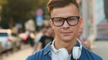 Kentin yol arka plan üzerinde boyun baş telefon ile bardaklarda şık adam görüntüsünü kapatın. Portre vurdu.