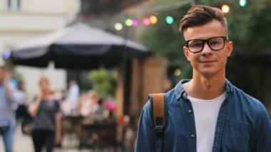 Kameraya bakarak ve şehirde gülümseyen bardakları mutlu adam. Açık atış.