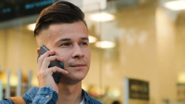 Modern şehir arka plan üzerinde akıllı telefonda konuşan genç çekici adam portresi kapatın.