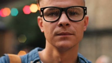 Şehir merkezinde fotoğraf makinesi isteyen gözlük, çekici bir adam portresi.