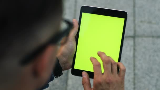 Primer plano de hombre atractivo usando tableta con pantalla verde mientras está sentado en la ciudad. Clave de croma . — Vídeos de Stock