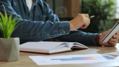 Ofiste çalışırken not defterindeki bir şey belirterek için tablet kullanarak adam el atış yukarıya kapatmak.