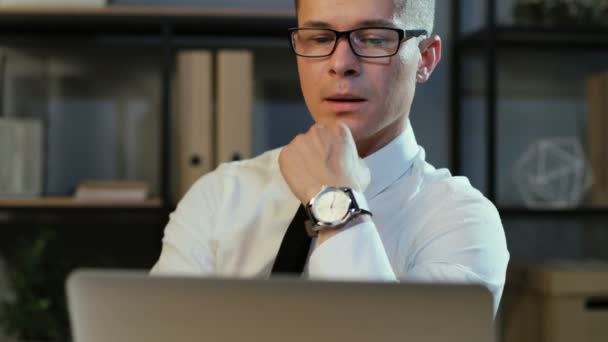 Porträt eines selbstbewussten jungen Geschäftsmannes im klassischen Hemd, der im stilvollen Büro am Laptop arbeitet. — Stockvideo