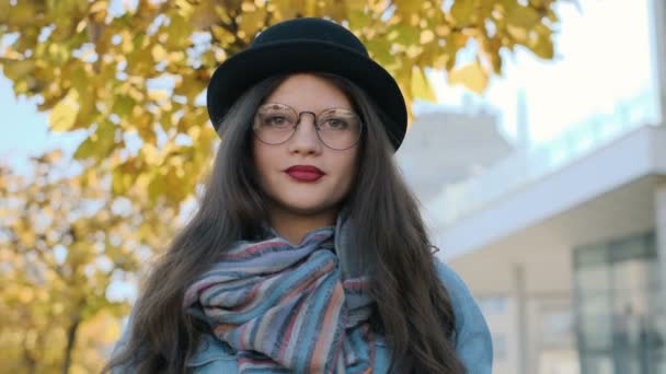 Closeup portret van lachende vrouw op zoek naar camera. Jong meisje kijken camera bij herfst stad achtergrond. — Stockvideo