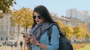 Bir smartphone aygıtında manifatura kadın portresi kapatın. Tipik metin haber ve müzik dışında cep telefonu üzerinde modern akıllı telefon kullanan güzel genç kadın
