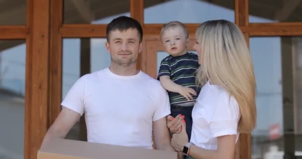 Casamento feliz com o filho a chegar a casa nova. Compra de imóveis, hipoteca, conceito em movimento. Família com caixas de papelão em casa nova no dia em movimento . — Vídeo de Stock