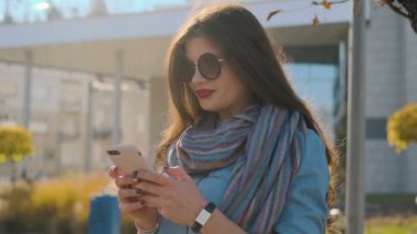 Bir smartphone aygıtında manifatura kadın portresi kapatın. Tipik metin haber dışında modern akıllı telefon kullanan güzel genç kadın